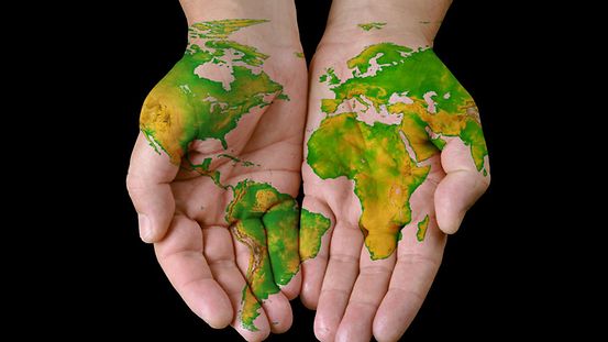 Eine Weltkarte ist auf Händen gemalt. Umwelt Natur Feature