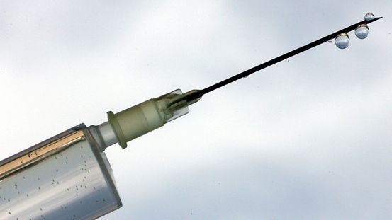 Eine Spitze mit einem Tropfen symbolisiert die Einnahme von Dopingmitteln.