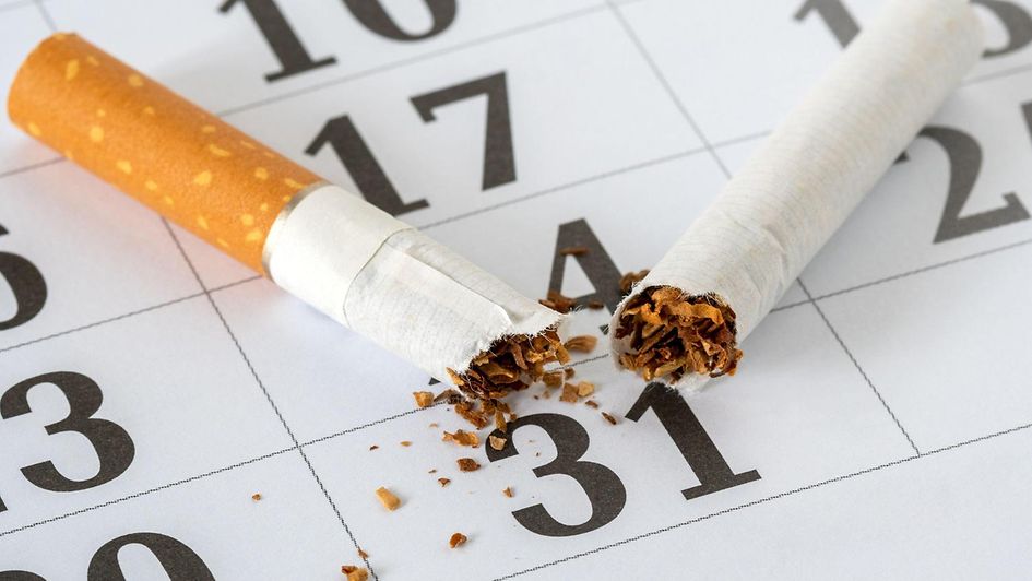 Eine durchgebrochene Zigarette liegt au einem Kalenderblatt.