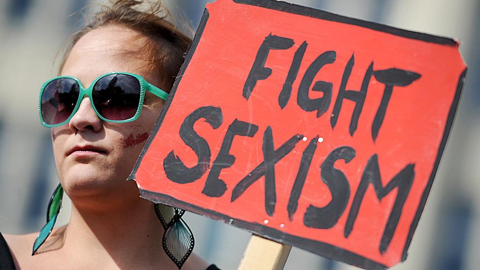 Eine Frau hält ein Schild mit der Aufschrift "Fight sexism"