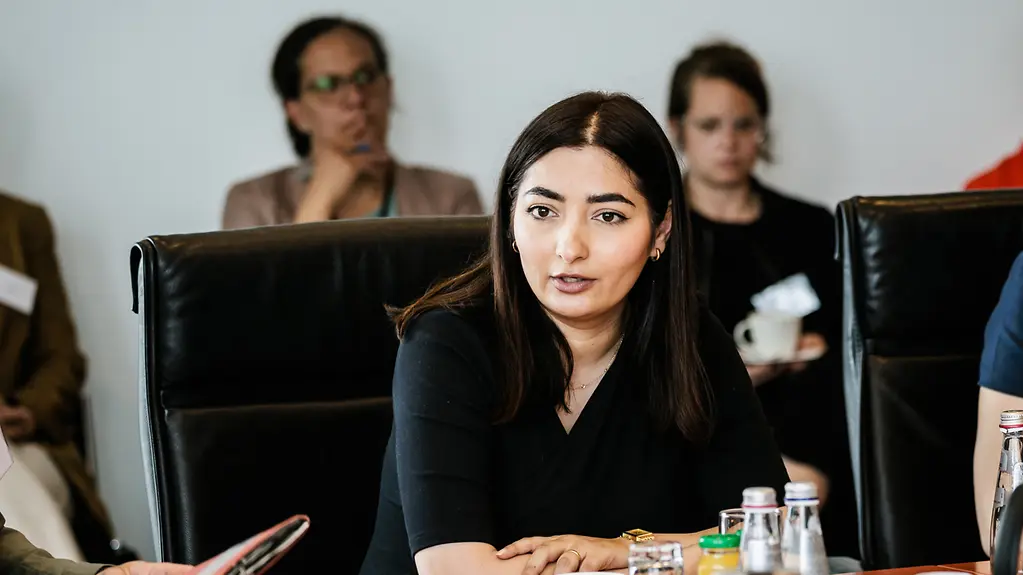 Staatsministerin am Tisch in einer Gespraechsrunde