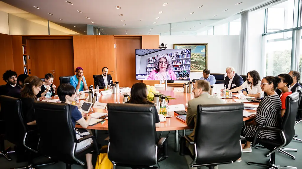 Staatsministerin am Tisch in einer Gespraechsrunde