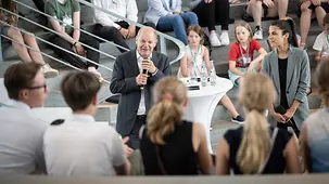 Bundeskanzler Olaf Scholz im Gespräch mit Schülerinnen und Schülern.