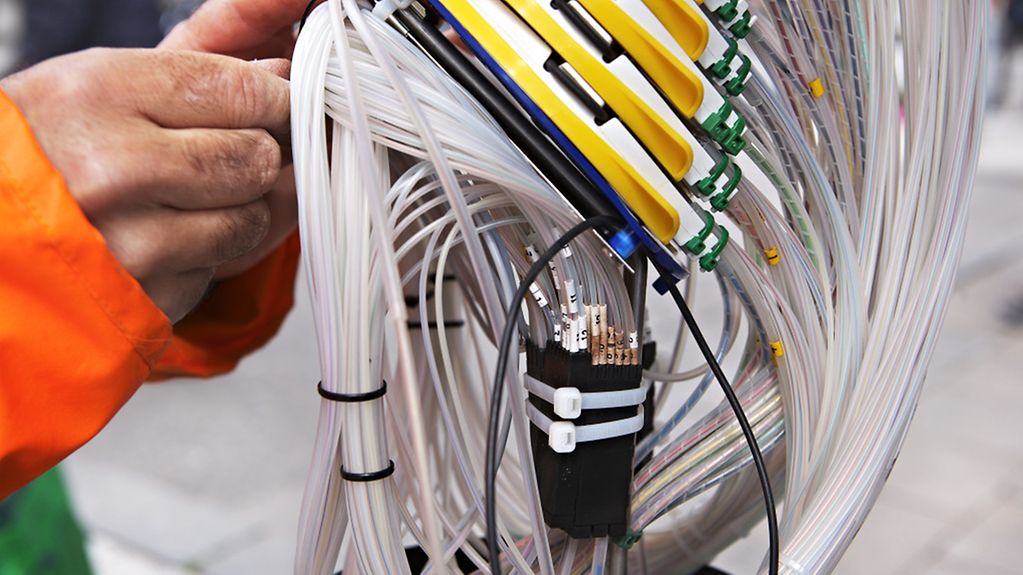 Techniker bei Glasfaserarbeiten an einem offenen Kabelstrang