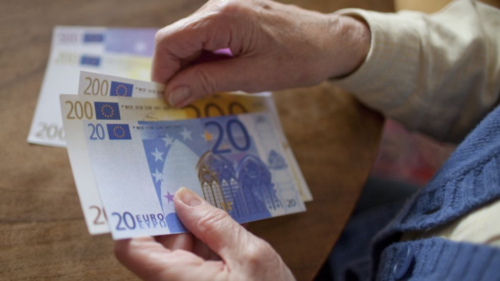 Seniorin hält Geldscheine in der Hand