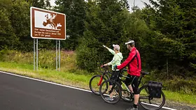 Paar mit Fahrrädern vor Schild