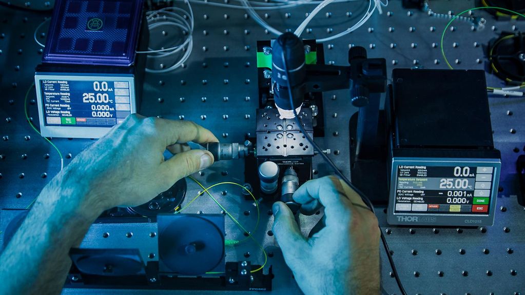 Ein Fiber Array wird mittels einer manuellen Stage und einem Mikroskop über einem Chip positioniert.