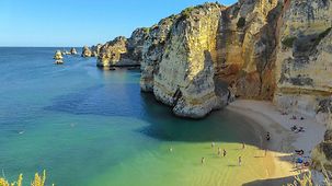 Blick auf einen Strand unter den Steilklippen der Desde Lagos an der Ponta da Piedade- Küste an der Algarve.