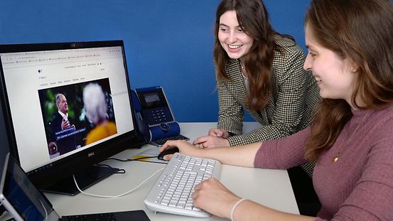 Zwei junge Frauen vor einem Computer.