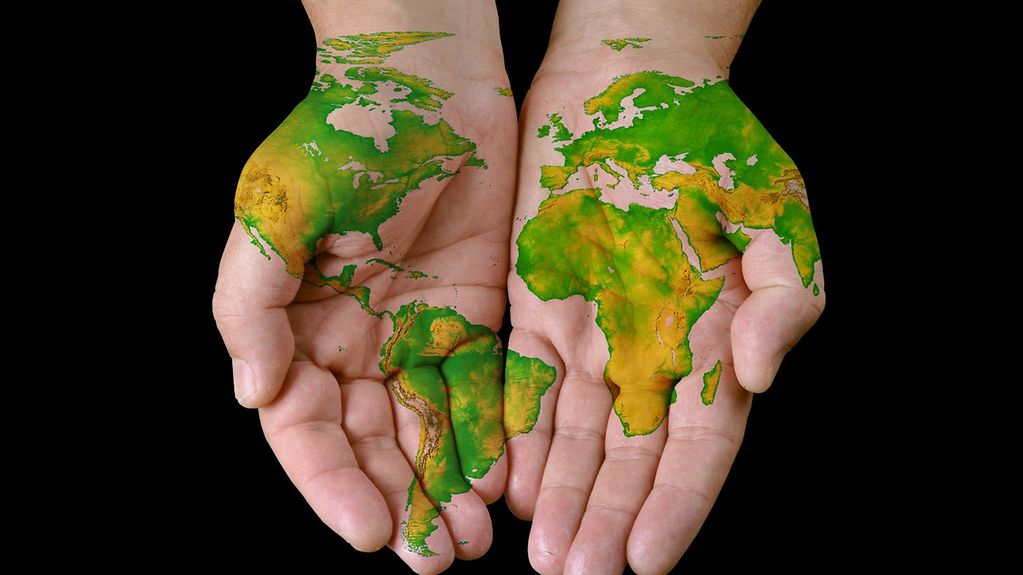 Weltkarte auf Menschenhände gemalt