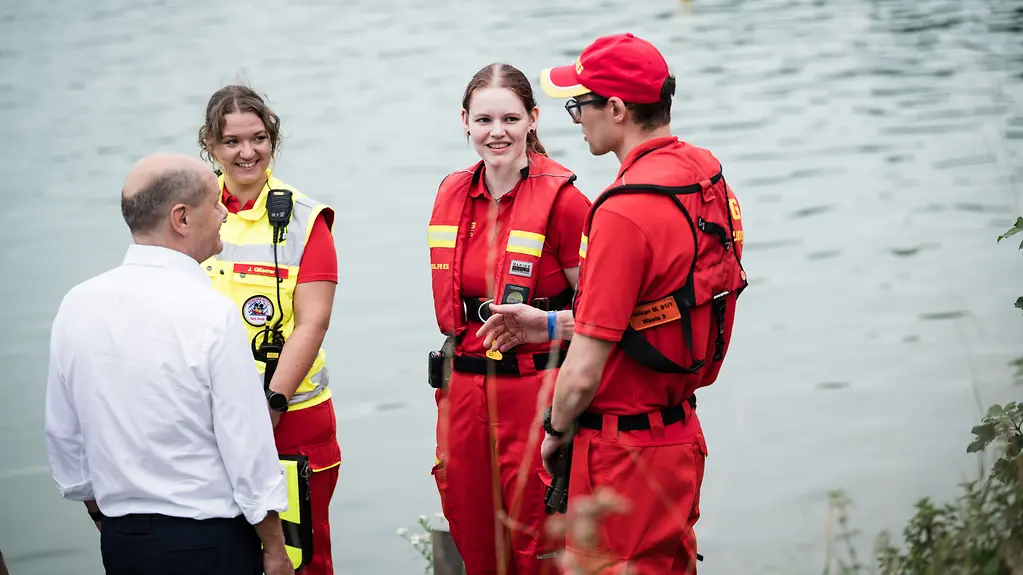 Kanzler Scholz im Gespräch mit DLRG-Rettungsschwimmern bei seinem Besuch am Fasaneriesee in München.