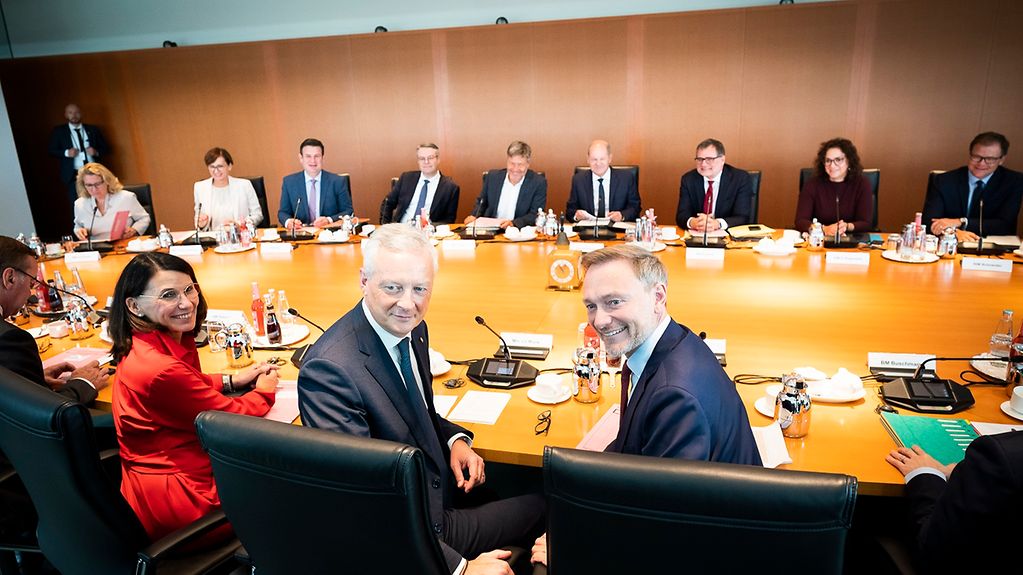 German cabinet ministers sitting at the cabinet table. French Minister of the Economy and Finance Bruno Le Maire is among them.