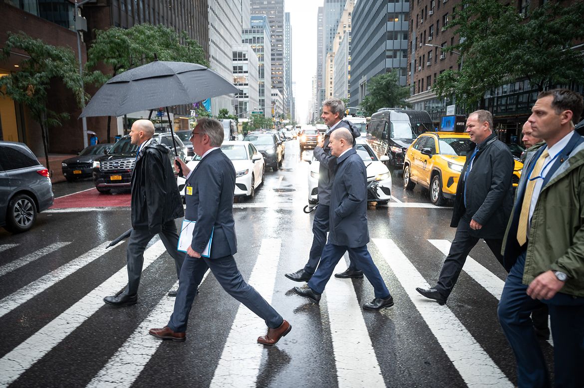 Bundeskanzler Olaf Scholz und Steffen Hebestreit, Sprecher der Bundesregierung, gehen in New York über einen Zebrastreifen.