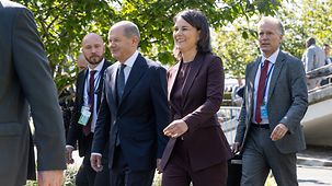 Bundeskanzler Olaf Scholz und Annalena Baerbock, Bundesministerin des Auswärtigen, gehen nebeneinander.