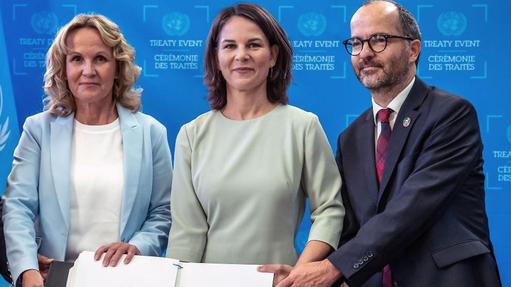 Außenministerin Annalena Baerbock, steht zwischen Bundesumweltministerin Steffi Lemke (links), sowie Sebastian Unger (rechts) Meeresbeauftragter der Bundesregierung. Vor ihnen das unternzeichnete Meeresschutzabkommens. 
