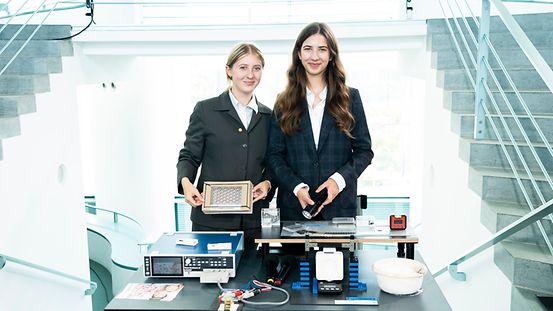 Charlotte Klar und Katharina Austermann posieren an ihrem Forschungsprojekt.