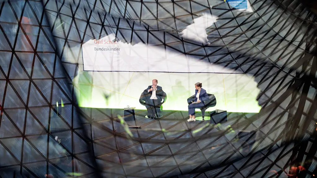 Bundeskanzler Scholz diskutiert auf der Bühne des Rats für Nachhaltige Entwicklung.