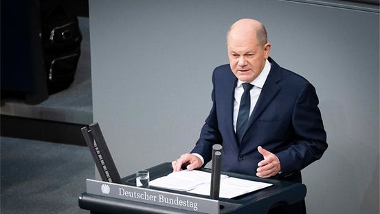 Bundeskanzler Olaf Scholz steht an einem Rednerpult im Deutschen Bundestag.
