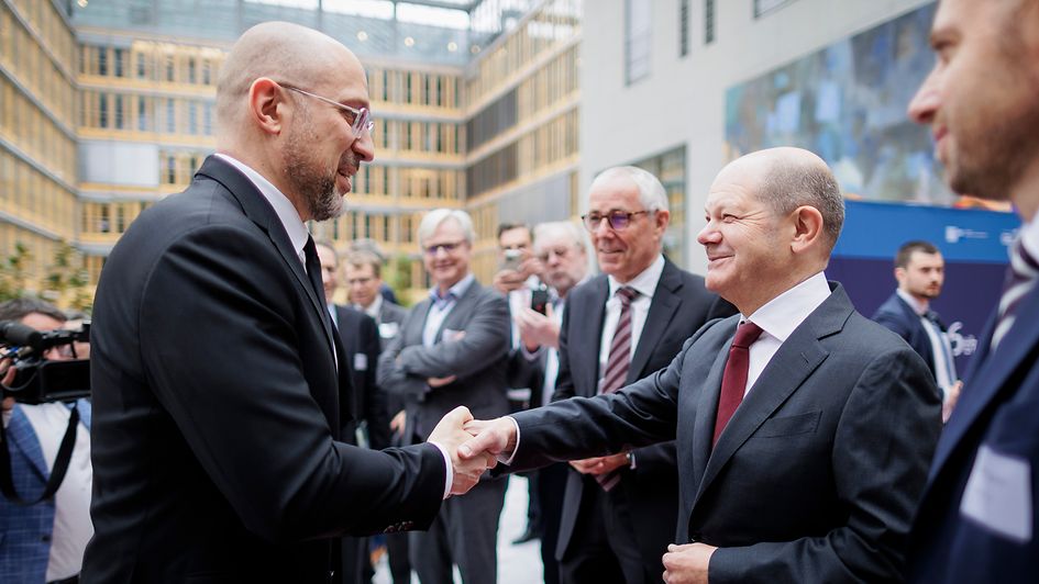 Bundeskanzler Olaf Scholz und Denys Schmyhal, Ministerpräsident der Ukraine, begrüßen sich beim Deutsch-Ukrainischen Wirtschaftsforum.