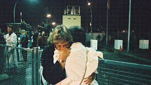 Two women hug at the Invalidenstraße border crossing point.