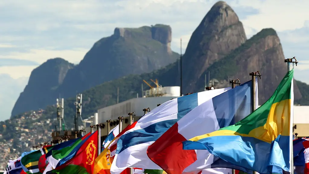Flags flutter in front of the Sugar Loaf Mountain