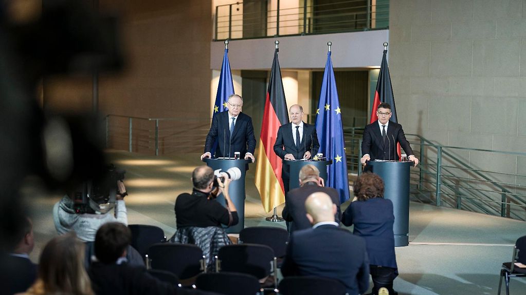Olaf Scholz, Boris Rhein und Stephan Weil sprechen im Kanzler-Amt vor der Presse.