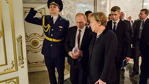 Bundeskanzlerin Angela Merkel unterhält sich mit Wladimir Putin.