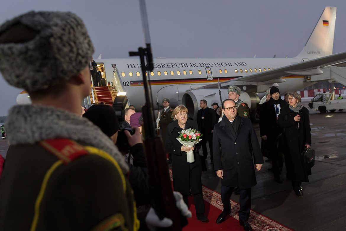 Bundeskanzlerin Angela Merkel und der französische Präsident François Hollande kommen am Flughafen an.