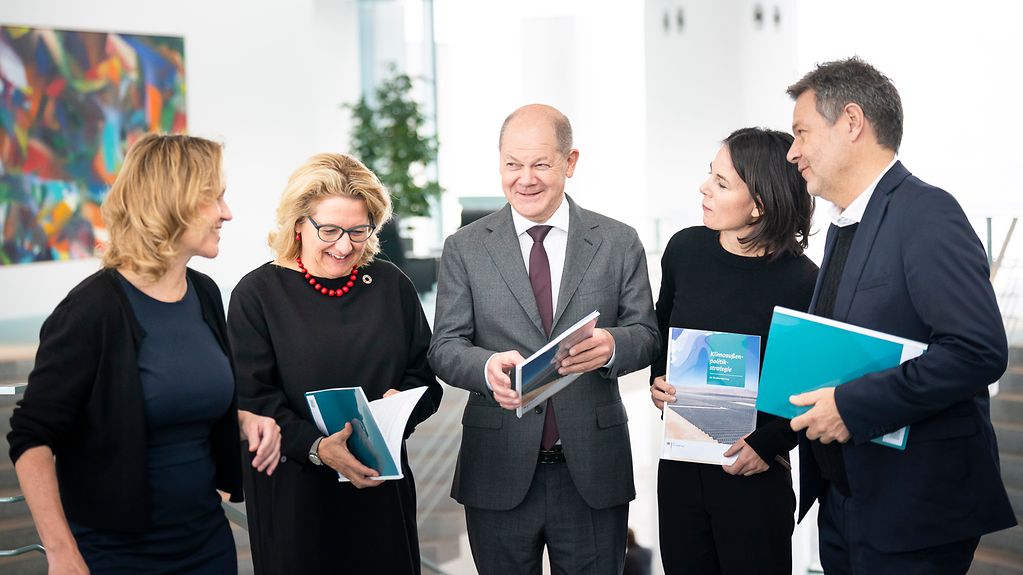 Steffi Lemke, Svenja Schulze, Bundeskanzler Olaf Scholz, Annalena Baerbock und Robert Habeck mit Exemplaren der Klimaaußenpolitik-Strategie.