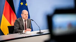 Le chancelier fédéral Olaf Scholz salue d’un geste de la main.