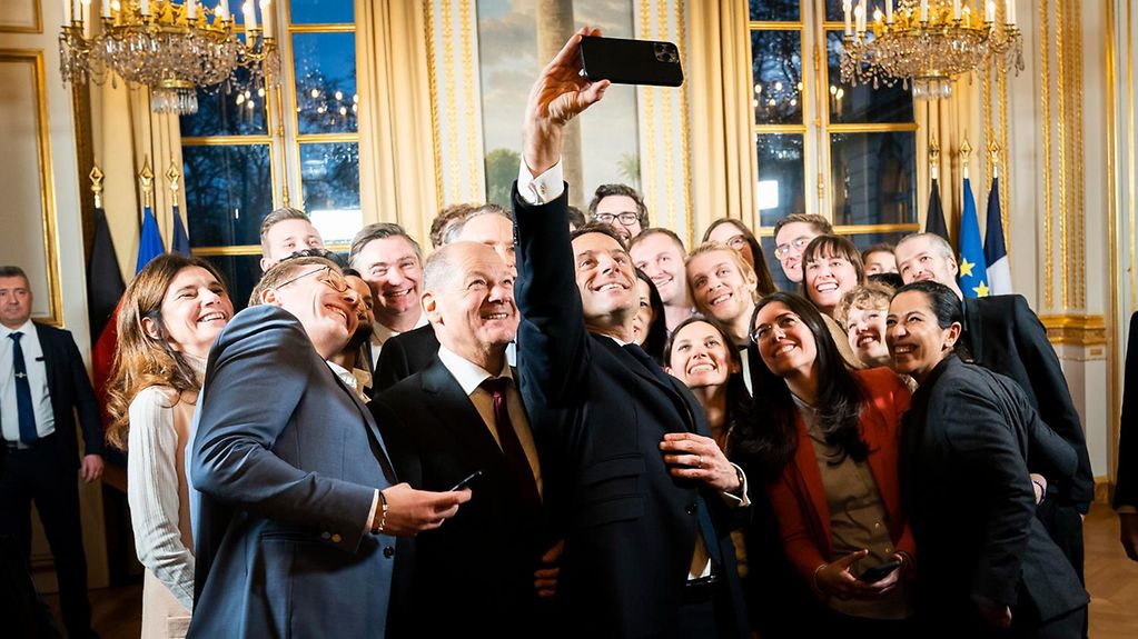 Bundeskanzler Olaf Scholz (M.) und Emmanuel Macron, Präsident Frankreichs (M.r.), mit Teilnehmenden des neuen, deutsch-französischen Nachwuchskräftenetzwerkes "Generation Europa", im Elysse-Palast.