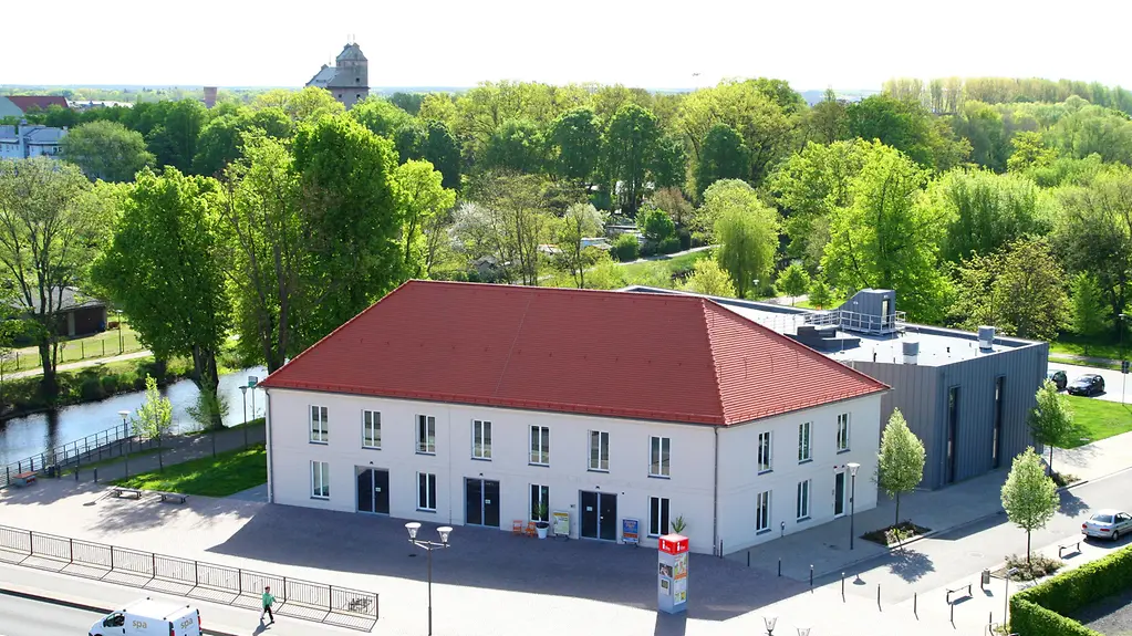 Luftaufnahme von einem Gebäude mit weißer Fassade und rotem Dach