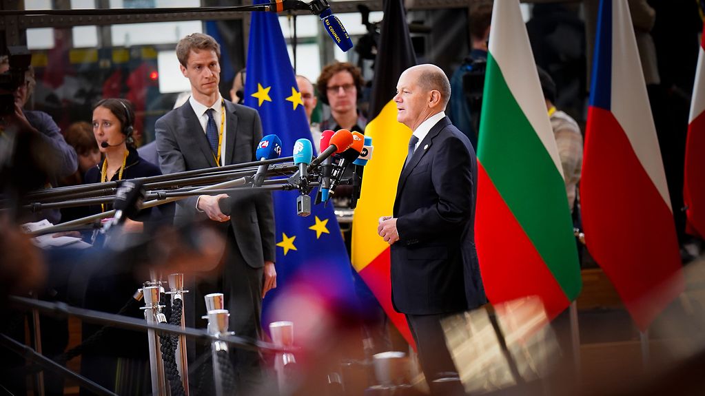 Le chancelier fédéral Olaf Scholz devant des microphones au Conseil européen