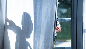 Das Foto zeigt ein Kind, das hinter einem weißen Vorhang steht. Auf dem Vorhang ist die Silhouette des Kindes als Schatten zu erkennen.