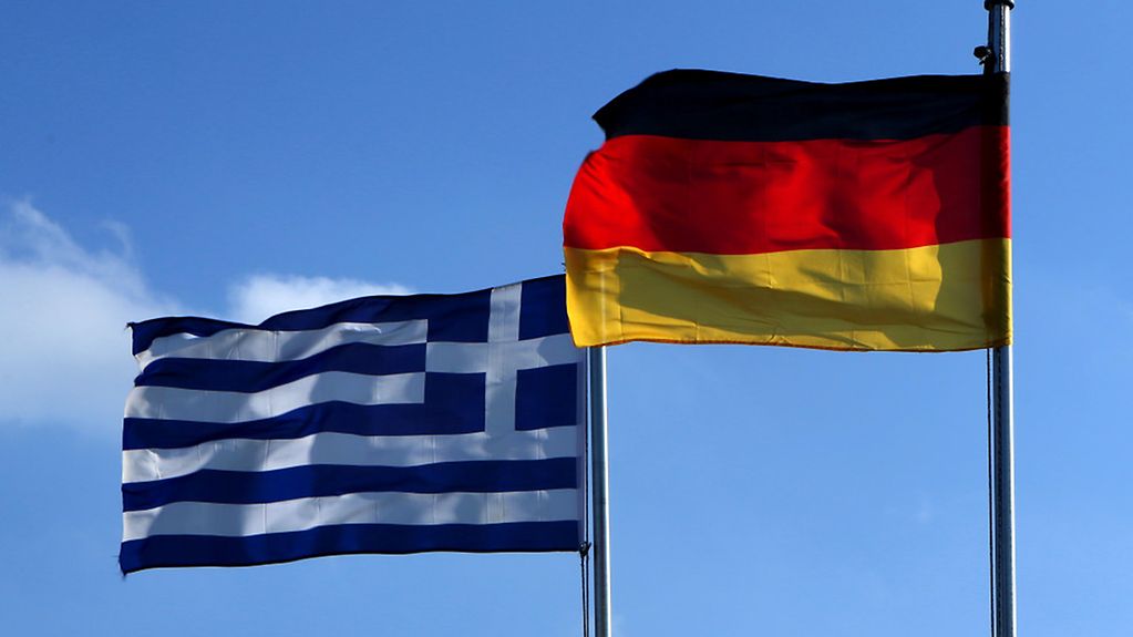 Die Fahnen von Deutschland und Griechenland wehen im Wind.