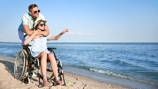 Frau im Rollstuhl auf Reise am Strand 