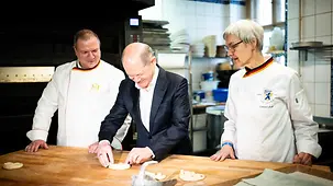 Bundeskanzler Scholz rollt in der Bäckerei SoLuna Brezeln