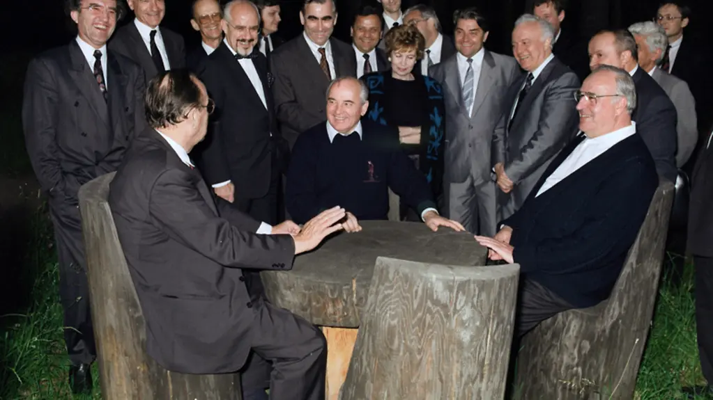 Bundeskanzler Helmut Kohl im Gespräch mit dem sowjetischen Michail Gorbatschow und Außenminister Hans-Dietrich Genscher an einem Holztisch über die volle Souveränität des vereinten Deutschlands.