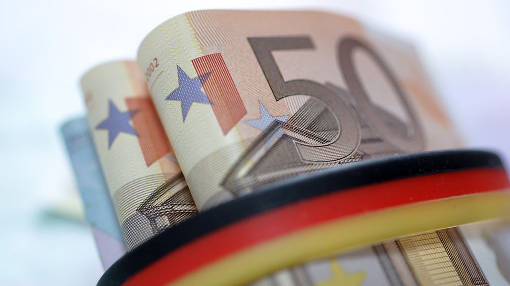 Euro-Geldscheine werden von einer schwarz-rot-goldenen Banderole zusammengehalten.