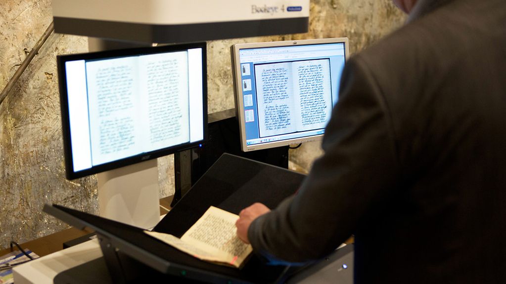 Ein Mitarbeiter scannt in der Staatsbibliothek Dokumente ein, um sie in die digitale europäische Bibliothek Europeana einzupflegen.