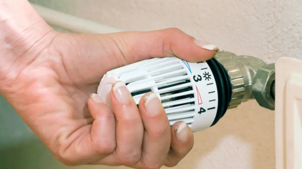 Hand an Temperaturregler der Heizung / Heizkoerperregelung, HeizkÃ¶rperregelung, HeizkÃ¶rpertermostat, heizen, Heizung, Energiekosten, Thermostat, Heizkoerper, HeizkÃ¶rper, Energiesparen