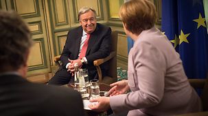 Bundeskanzlerin Angela Merkel unterhält sich bei Münchener Sicherheitskonferenz mit UN-Generalsekretär António Guterres.
