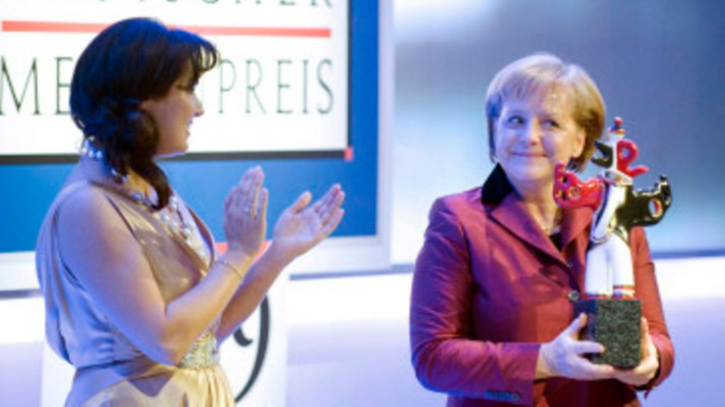 Bundeskanzlerin Angela Merkel bekommt den Deutschen Medienpreis von Sopranistin Anna Netrebko überreicht