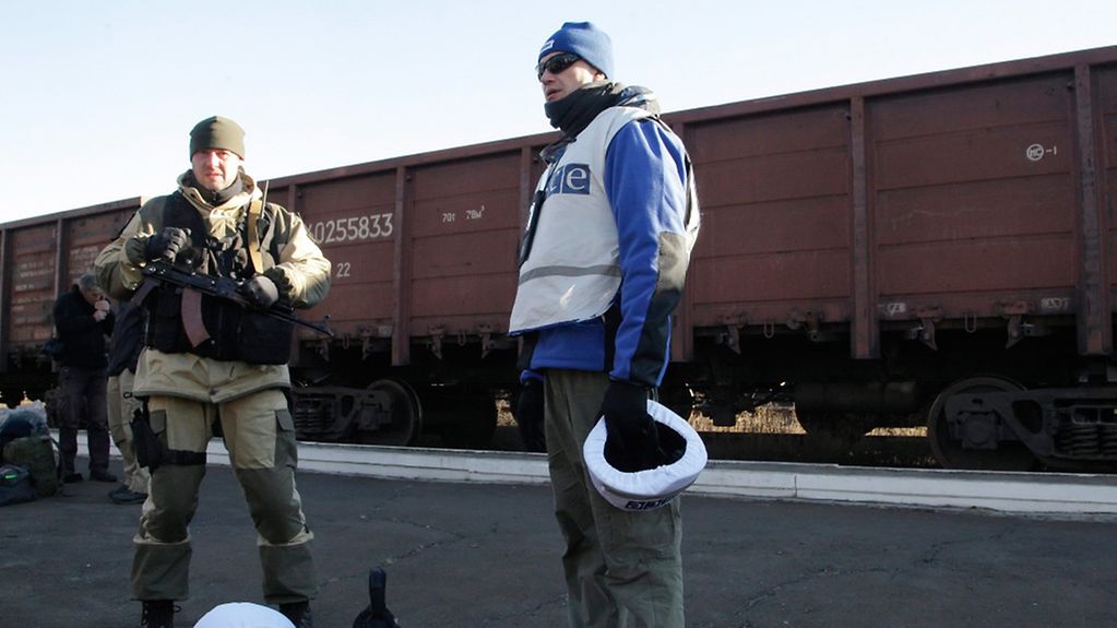 Ein OSZE-Beobachter überwacht den Abtransport von Wrackteilen eines abgeschossenen Flugzeugs