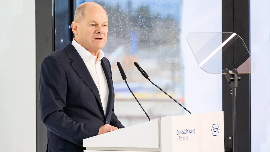Kanzler Scholz am Rednerpult bei Pharmaunternehmen Roche.