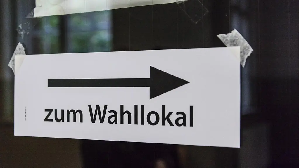 Ein Zettel mit einem Pfeil und der Aufschrift: zum Wahllokal