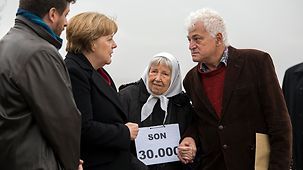 La chancelière Angela Merkel s'entertien dans le Parc du souvenir avec des proches de personnes disparues