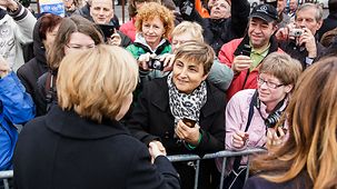 Bundeskanzlerin Angela Merkel wird von Zuschauern begrüßt.