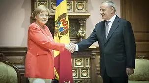 Präsident Timofti begrüßt die Kanzlerin vor einer moldauischen Fahne.