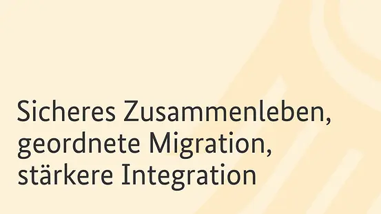 Auf dem Foto zu sehen ist die Aufschrift "Sicheres Zusammenleben, geordnete Migration, stärkere Integration" auf einem hellgelben Hintergrund.